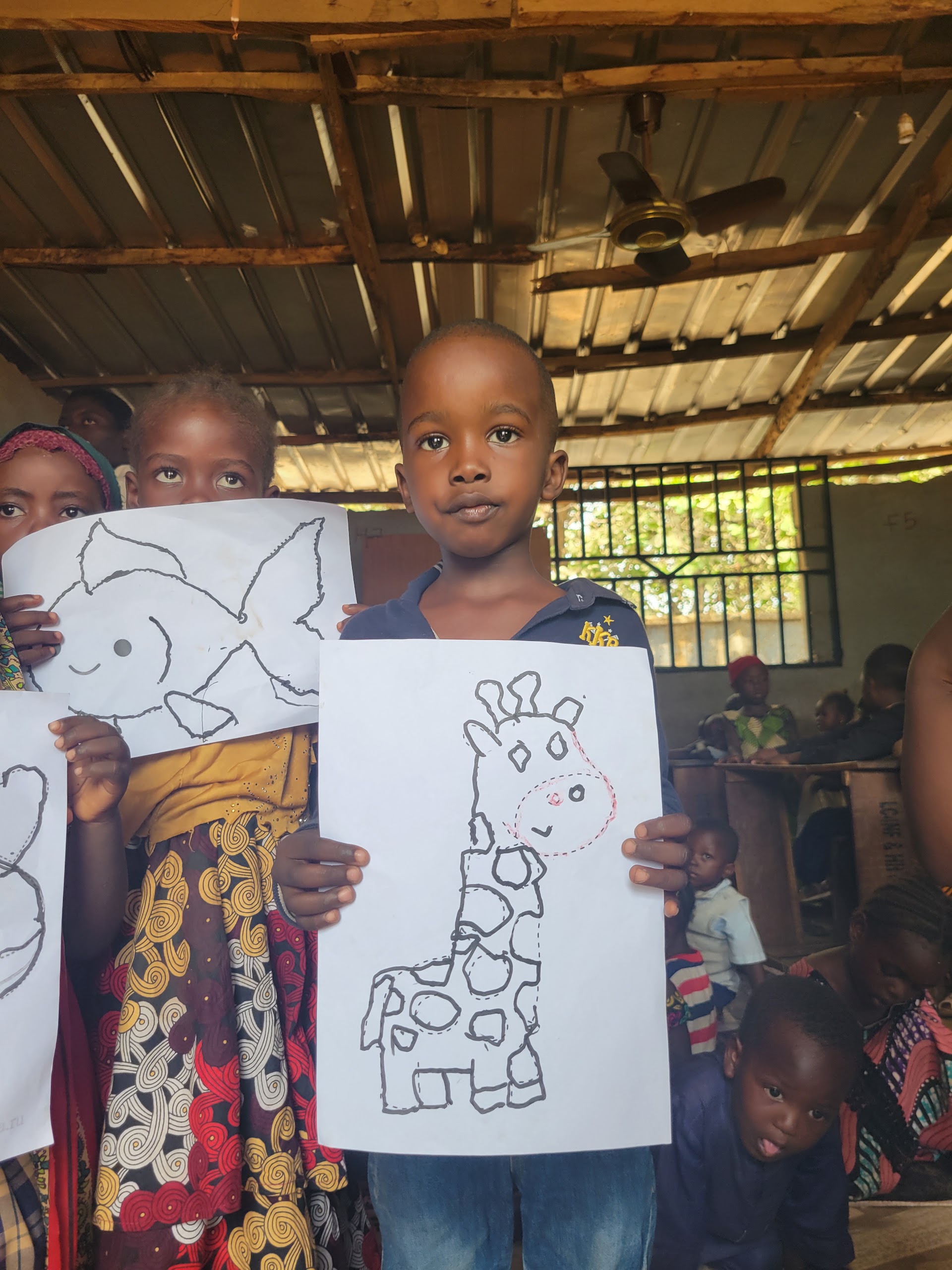 Children showing artwork at IDP Outreach