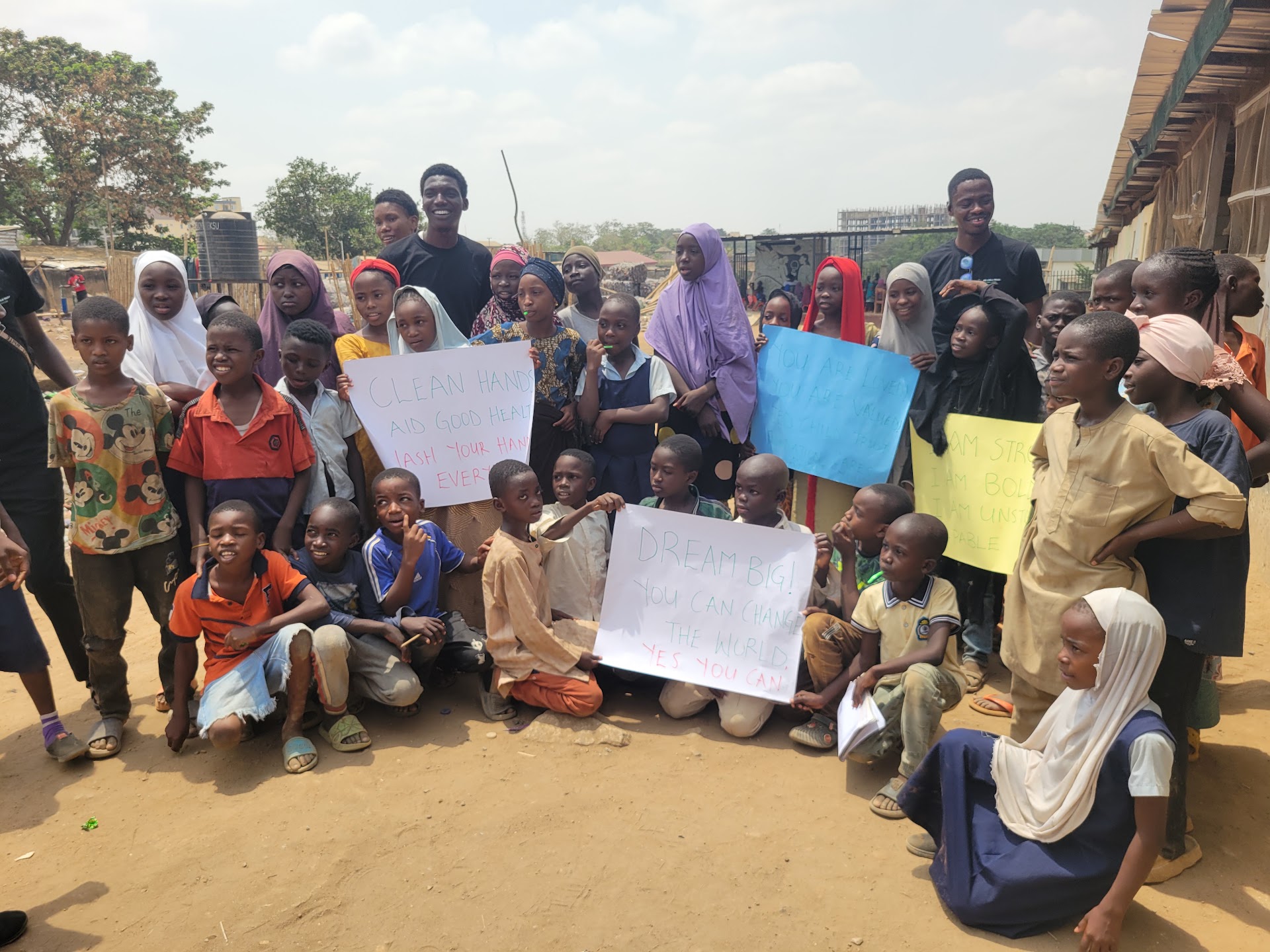 Children holding hand-made awareness signs at IDP Outreach