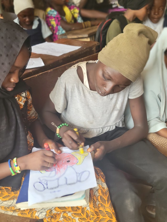 Children drawing together at IDP Outreach